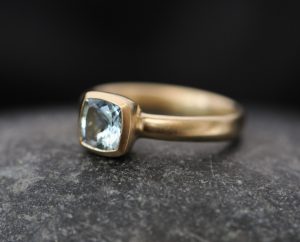 Cushion cut aquamarine stone set in yellow gold ring