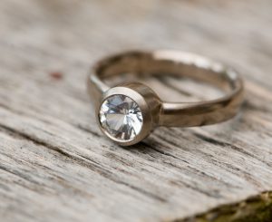Brilliant cut white sapphire solitaire in white gold ring