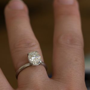 moissanite oval claw ring in 18K white gold on hand