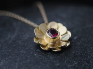 Ruby daisy necklace in 18K yellow gold.