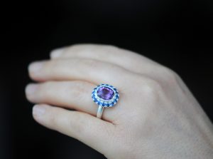 purple amethyst and sapphire halo ring in silver on hand