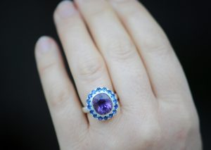 purple amethyst and sapphire halo ring in silver on hand
