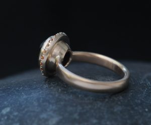 black-diamond-9mm-and-sapphire-halo-ring-18K-rose-gold-on-hand-2