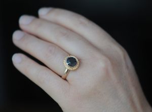 black-diamond-9mm-and-sapphire-halo-ring-18K-rose-gold-on-hand-2