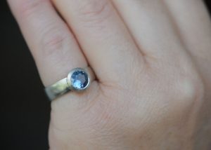 blue-montana-sapphire-wide-band-wide-bezel-ring-18K-white-gold-on-hand-close-up