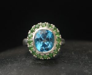 swiss-blue-topaz-halo-ring-with-tsavorite-garnets-in-silver-front