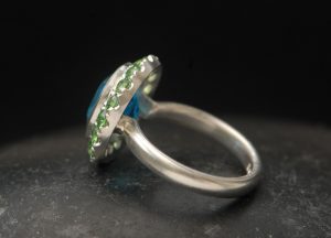 swiss-blue-topaz-halo-ring-with-tsavorite-garnets-in-silver-left-side