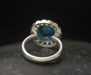 swiss-blue-topaz-halo-ring-with-tsavorite-garnets-in-silver-reverse