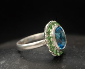 swiss-blue-topaz-halo-ring-with-tsavorite-garnets-in-silver-right-side