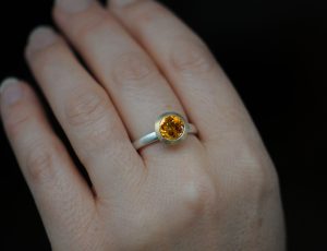 aquamarine-8mm-18K-gold-halo-and-silver-band-on-finger
