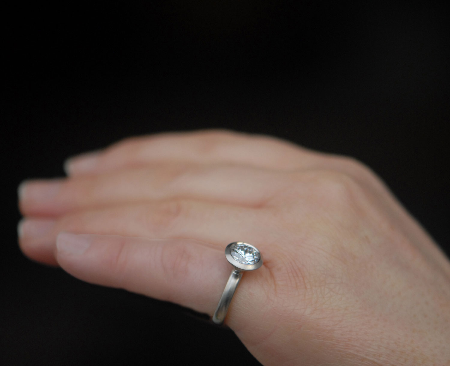 lab-diamond-8mm-halo-ring-in-18K-white-gold-on-hand-side-angle