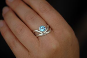 swiss-blue-topaz-wave-ring-in-silver-on-hand-2
