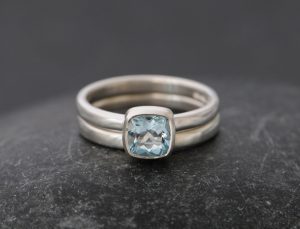 Sparkly cushion cut aquamarine engagement ring in silver with matching wedding band
