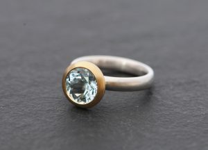 aquamarine stone set in gold bezel on sterling silver ring