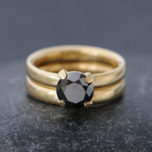 claw set black diamond solitaire in yellow gold engagement ring, with satin finish yellow gold wedding band