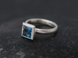 Contemporary square setting princess cut blue topaz in silver ring. By William White