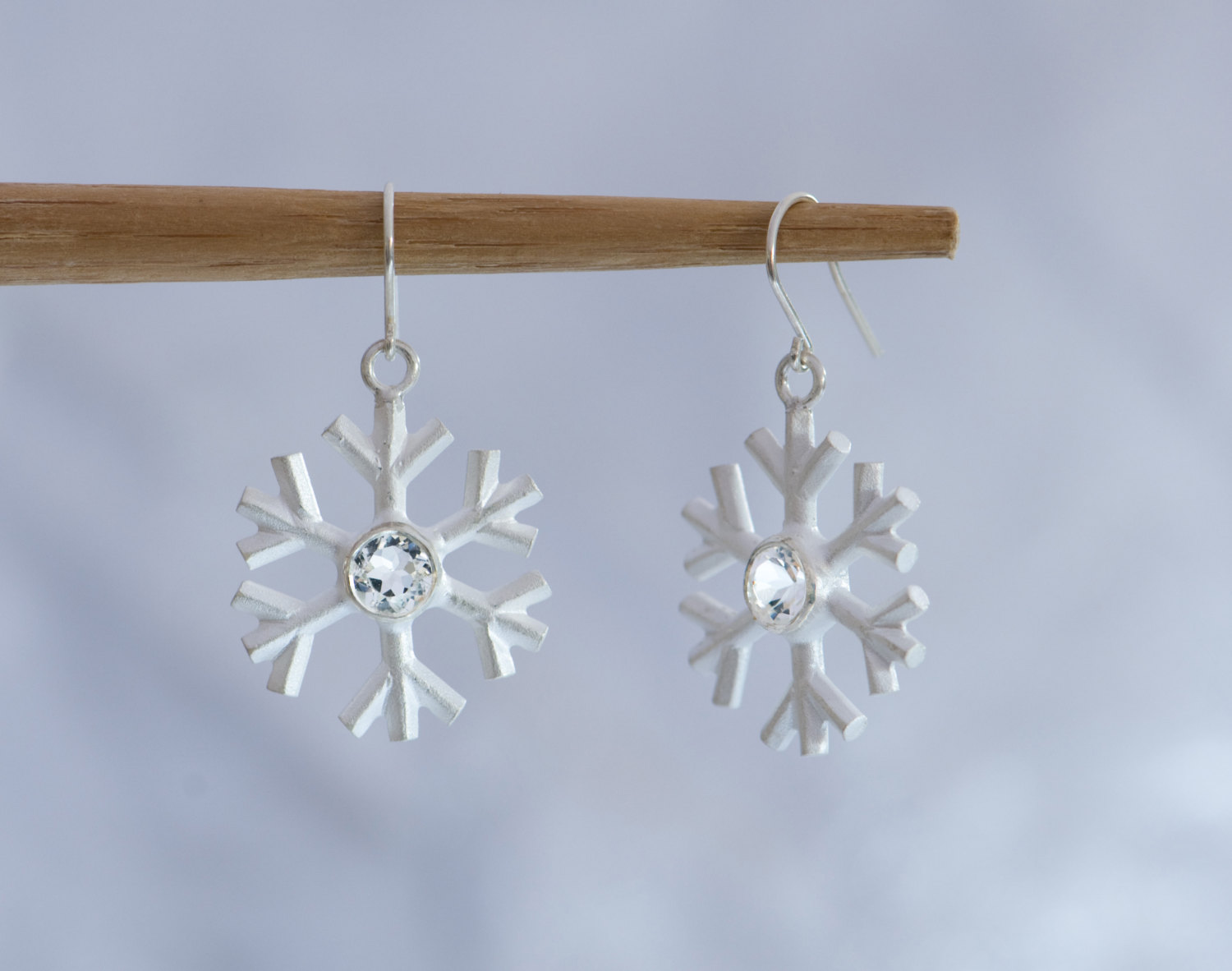 A perfect winter gift. White topaz snowflake earrings, set in sterling silver. Snowflake 20mm across, stone 5mm. Designed and handmade by William White, UK