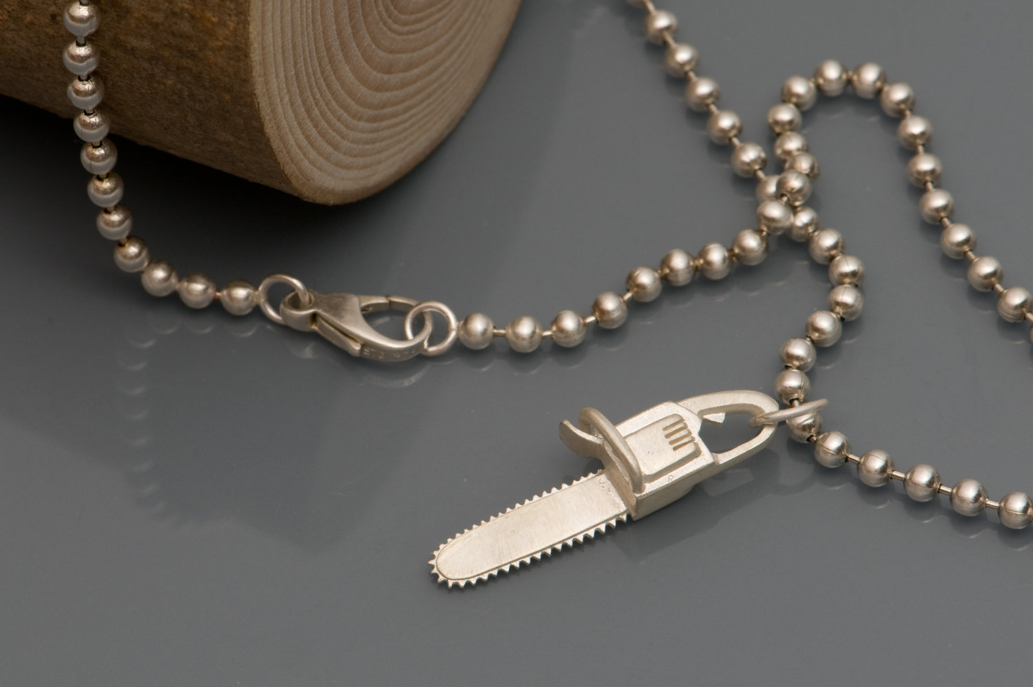 Chainsaw 'killer charm' pendant in solid silver, on a sterling silver ball chain necklace. 'Killer Charm' collection designed and handmade by William White.
