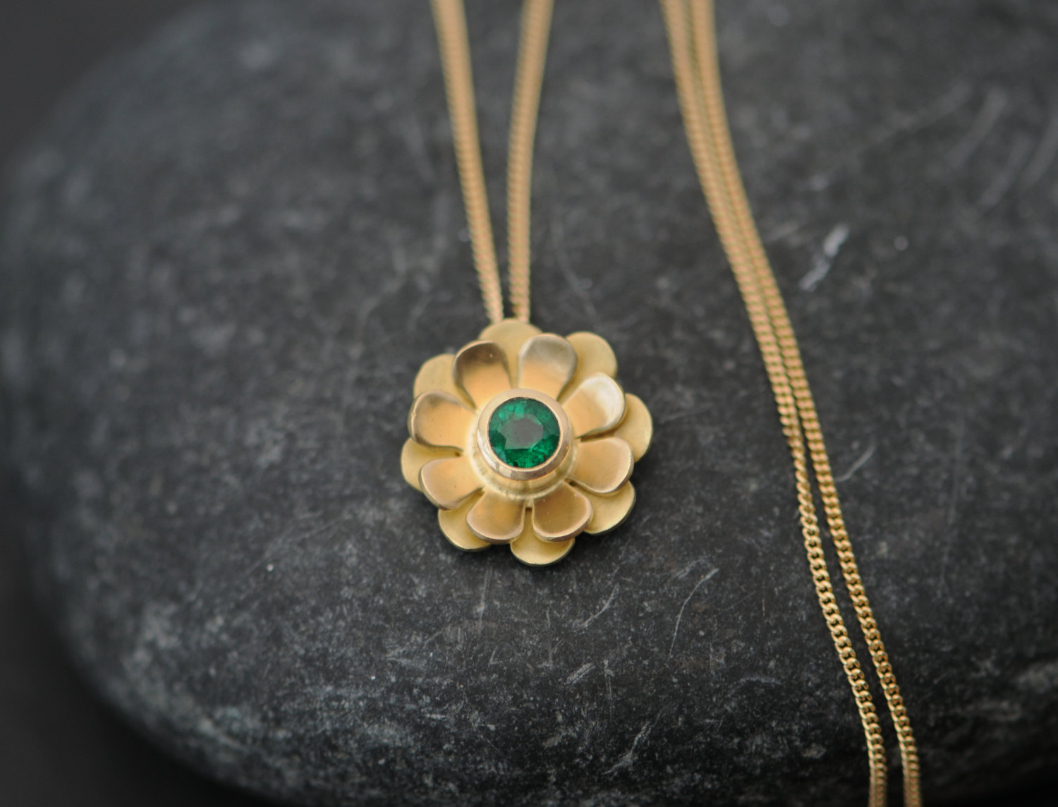 Beautiful emerald daisy pendant necklace, set in 18k gold. This gold and emerald necklace is designed and handmade by William White in Cornwall, UK.