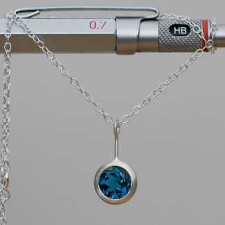 clean and simple London blue topaz 'Lollipop' necklace, set in sterling silver. Blue topaz stone is 8mm and the pendant is 10mm. By William White