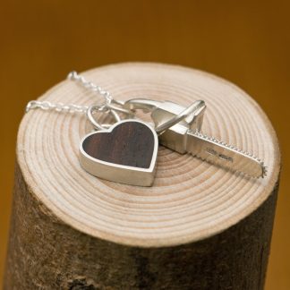 Killer Charm necklace with Silver chainsaw & silver heart set with reclaimed rosewood, on a fine silver necklace. Designed and handmade by William White