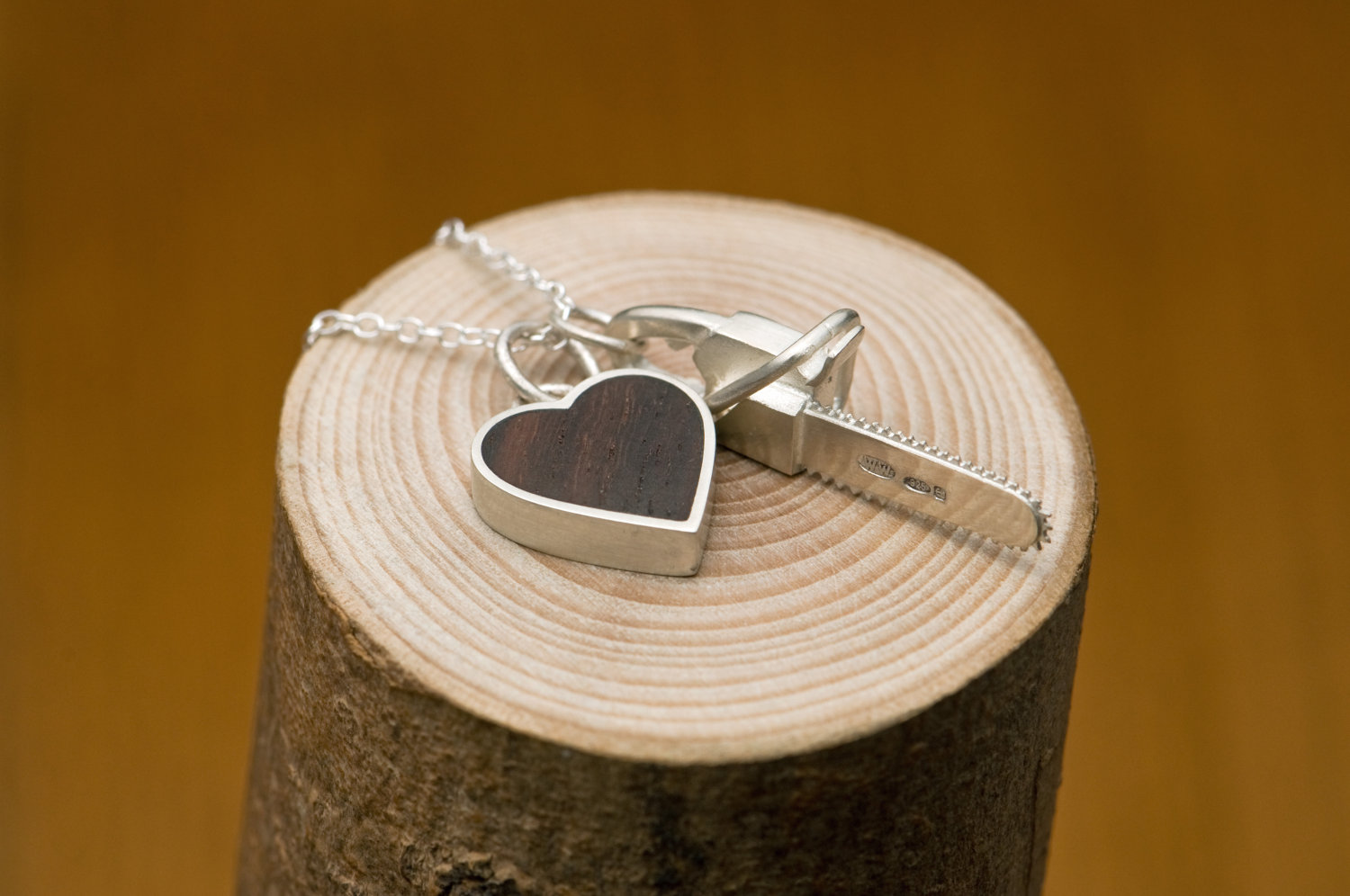 Killer Charm necklace with Silver chainsaw & silver heart set with reclaimed rosewood, on a fine silver necklace. Designed and handmade by William White