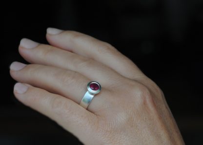 ruby wide band wide bezel silver ring on hand