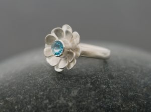 Bright blue Swiss blue topaz stone set in silver daisy ring