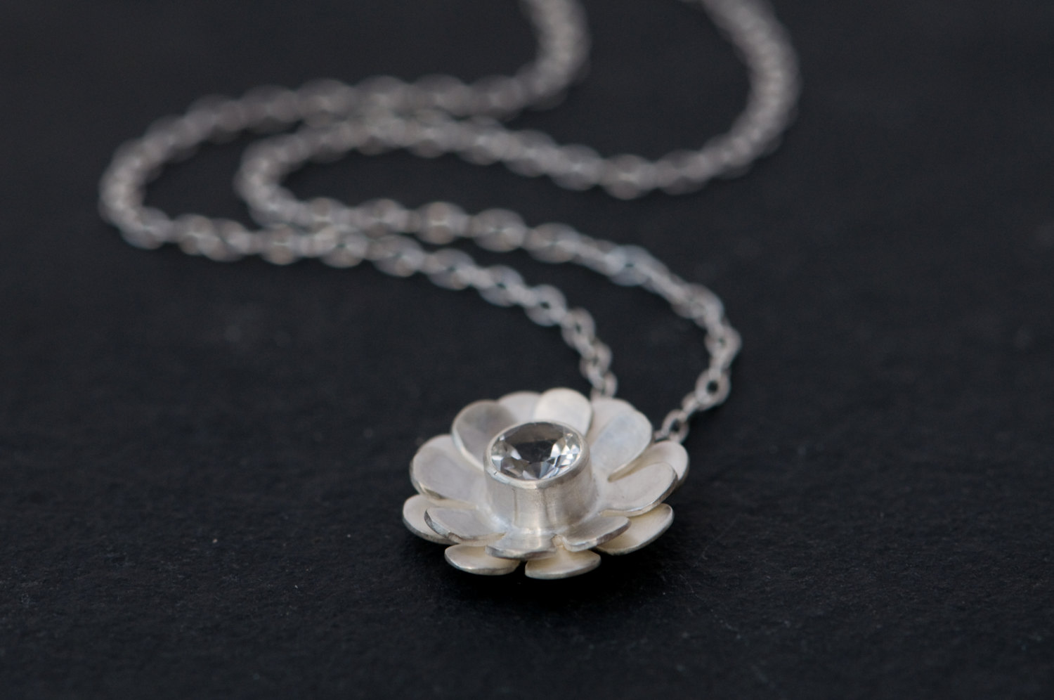 Pretty White Topaz daisy design, set in satin finished sterling silver on a silver chain. Designed and handmade by William White in Cornwall, UK.