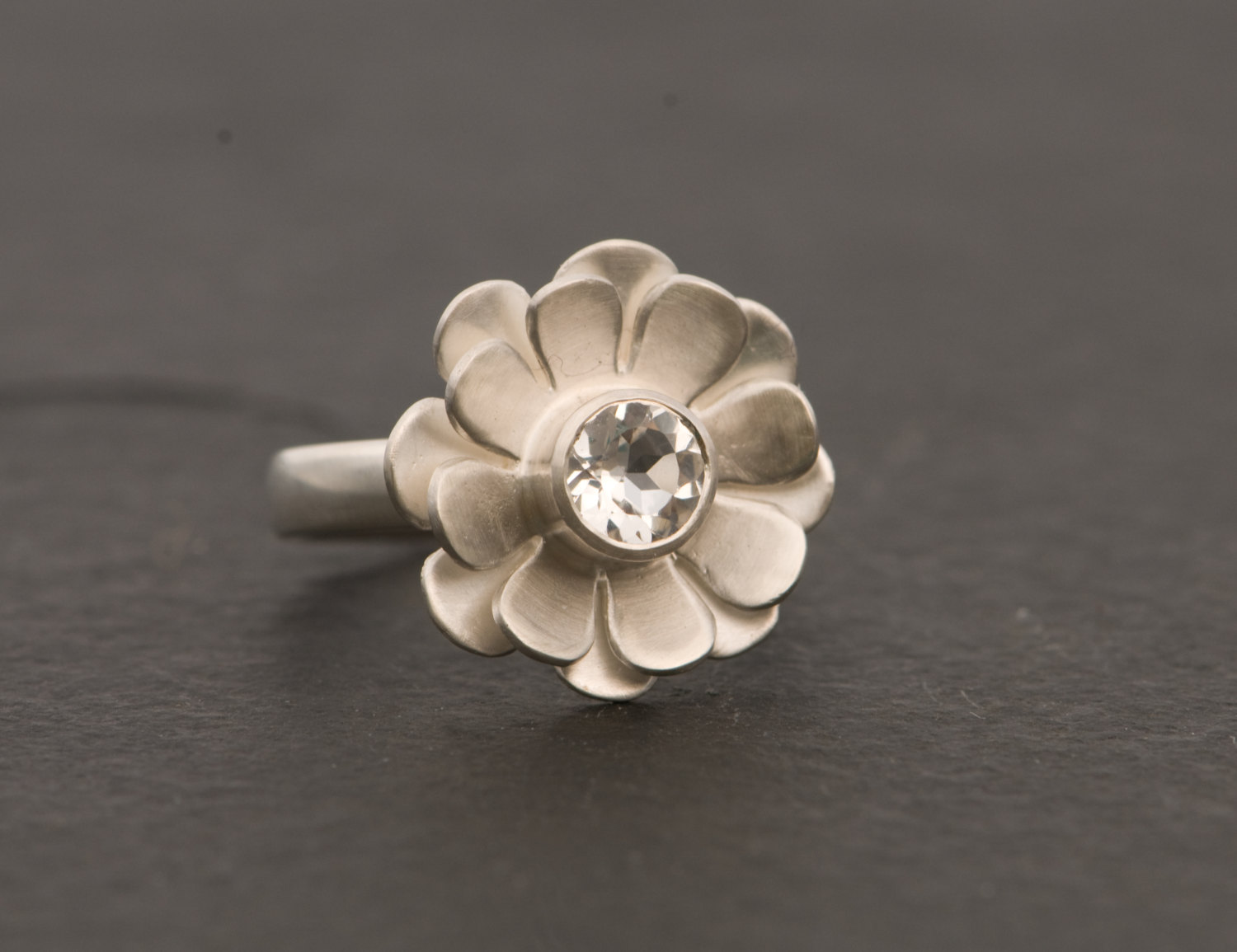 White topaz solitaire set in silver daisy ring