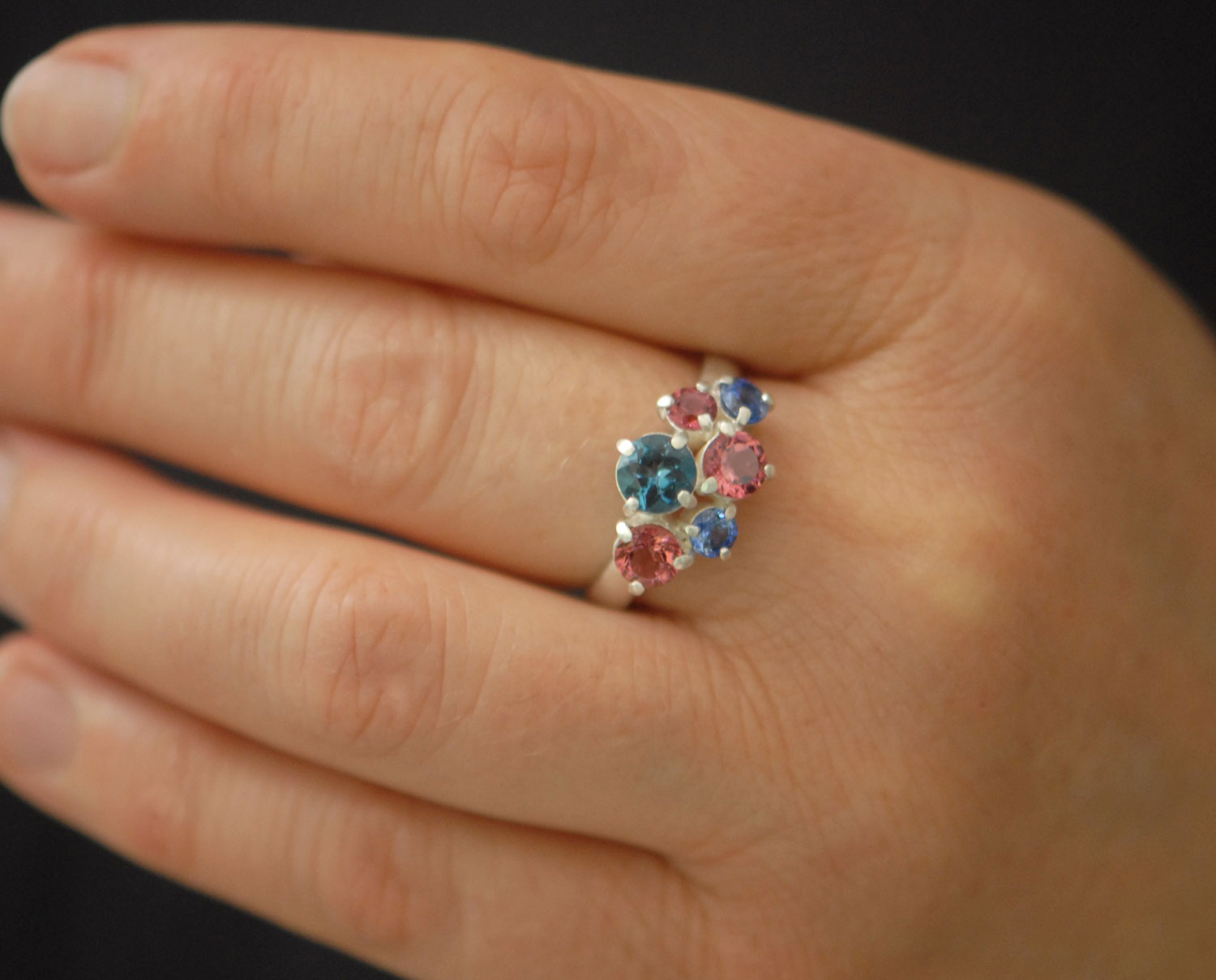 Topaz,-tourmailne-and-sapphire-cluster-ring-in-silve-on-hand-closeup