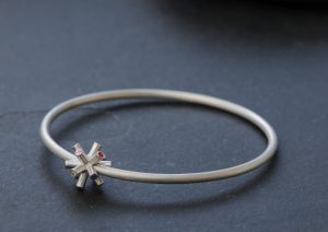 Particle collision bangle with sapphires in silver
