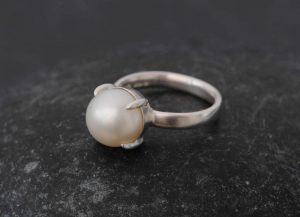 White pearl claw set into silver ring