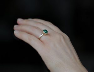 emerald 8mm cab ring in 18K gold on hand