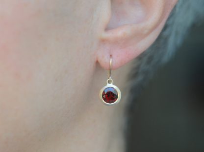 red garnet 8mm drop earrings in 18K rose gold on ear