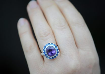 purple amethyst and sapphire halo ring in silver on hand