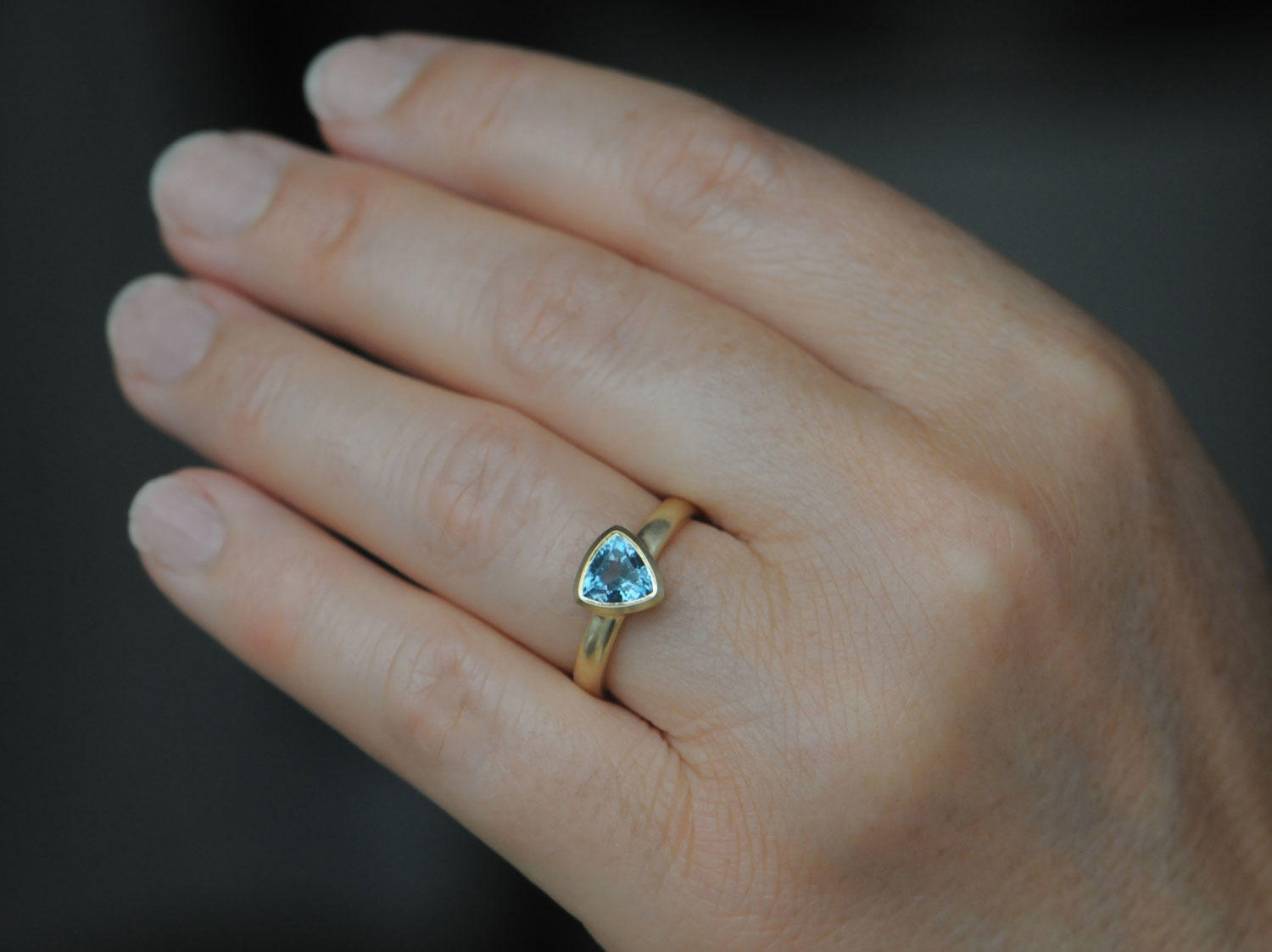 aquamarine-7mm-trillion-ring-in-18K-yellow-gold-on-hand
