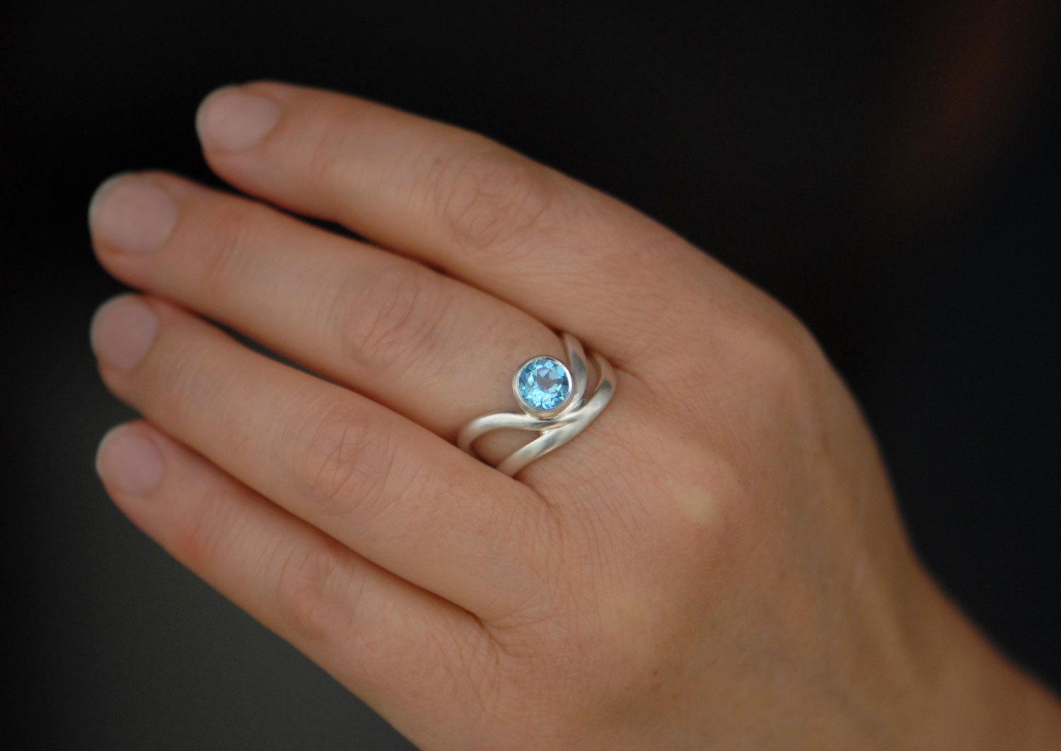 swiss-blue-topaz-wave-ring-in-silver-on-hand-2